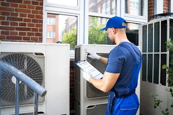HVAC technician inspecting outdoor air conditioning equipment